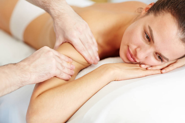 Розслаблена жінка насолоджується професійним масажем тіла в спа-салоні
 - Фото, зображення