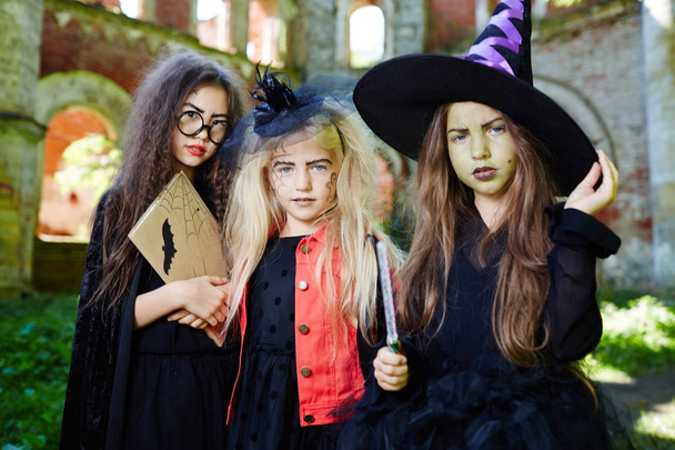 Groep van vriendelijke heksen in halloween-kostuums die je vraagt om een traktatie - Foto, afbeelding