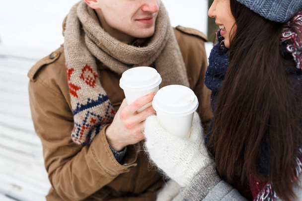 Plastic glasses with hot drinks in hands of amorous couple - Фото, зображення