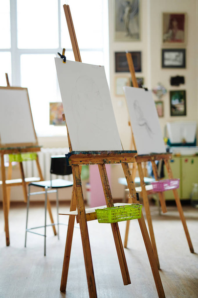 Easels with paper-sheets in empty studio of arts - Φωτογραφία, εικόνα