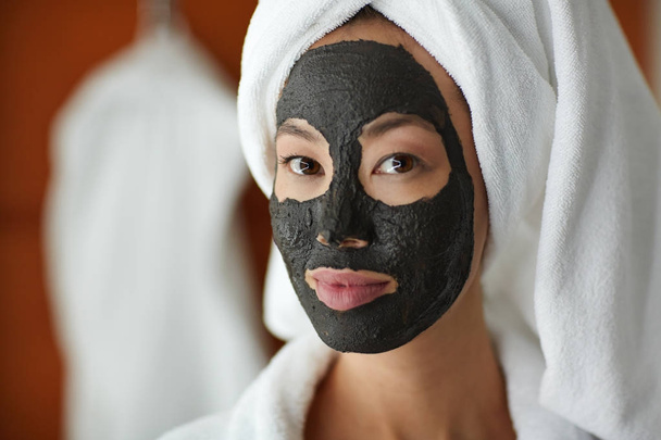 Retrato de bela mulher asiática aplicando máscara facial
  - Foto, Imagem