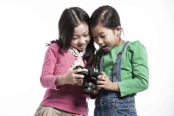 2 つのアジアの女の子が写真を撮るし、再生. - 写真・画像
