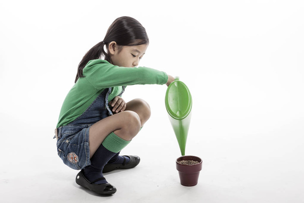 cute girl watering a plant. - Foto, Imagen