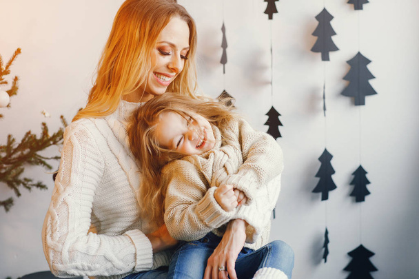 mother and daughter sitting by holiday decorations - Foto, Bild