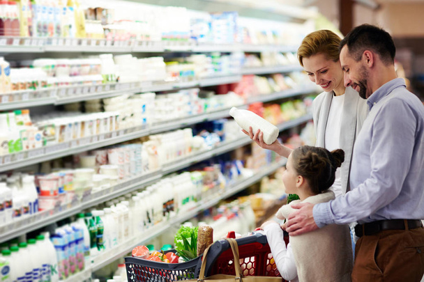 Modern family choosing dairy products in supermarket - Фото, изображение