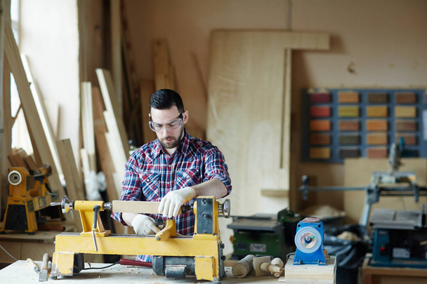 Людина в рукавичках і захисних окулярах деревообробка в робочій кімнаті
 - Фото, зображення