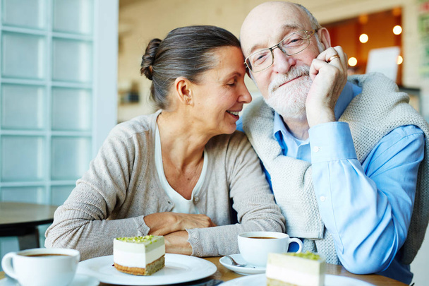 Affectionate spouses having dessert and tea in cafe - Photo, Image