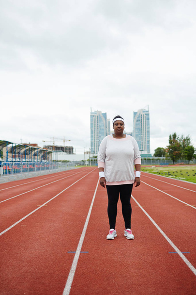 Young plump woman in activewear standing on one of racetracks - Fotoğraf, Görsel