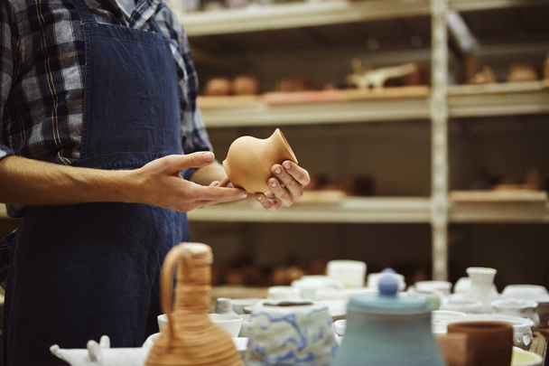 Řemeslník keramika drží malý keramický džbán - Fotografie, Obrázek