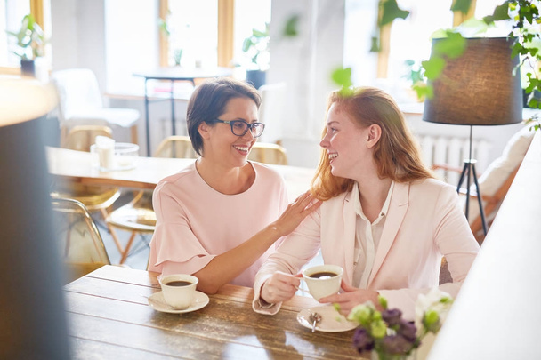 Две счастливые женщины наслаждаются кофе-брейком в кафе
 - Фото, изображение