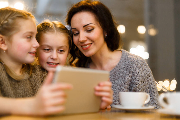 Gemelli piccoli con touchpad e la loro madre con intrattenimento online
 - Foto, immagini
