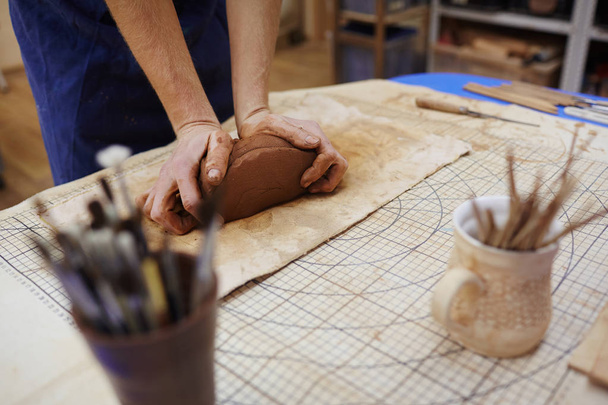 Potter kneading clay on table - Photo, Image