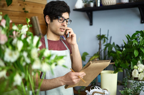 Florist ordering new sorts of flowers by phone - Photo, image