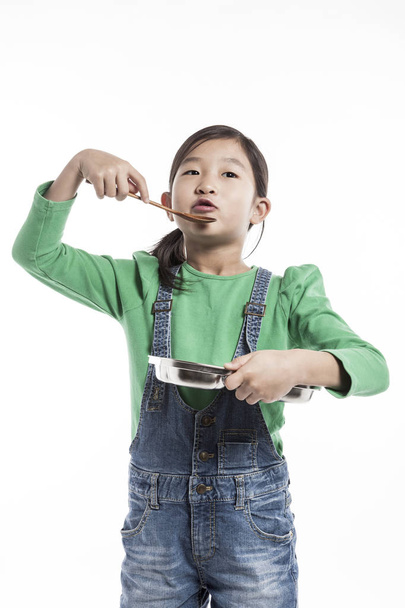 Cute asian dívka drží desku a vařečka. - Fotografie, Obrázek