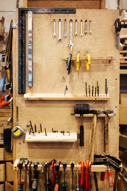 Фон изображения различных деревообрабатывающих инструментов на стенде в мастерской плотников
 - Фото, изображение