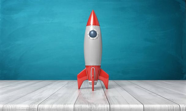 3d rendering of a red and silver realistic model of a retro rocket stands on a wooden desk on a blue background. - Фото, изображение