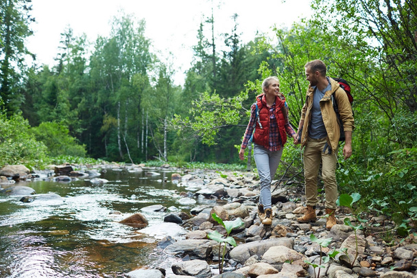Šťastné turisty pěšky podél řeky v lese - Fotografie, Obrázek
