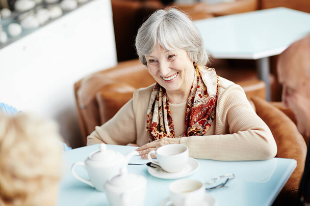Vita-up ritratto di bella donna anziana con ampio sorriso divertendosi con i suoi migliori amici mentre seduto in accogliente piccola caffetteria
 - Foto, immagini