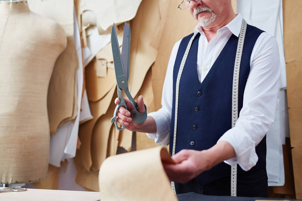 Portrait d'un tailleur habile coupant des motifs de vêtements tout en faisant des vêtements dans un petit atelier
 - Photo, image
