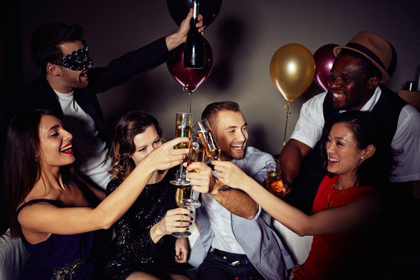 Tre bell'uomo e tre belle donne brindano con champagne mentre si godono la compagnia a casa festa, ritratto di gruppo
 - Foto, immagini