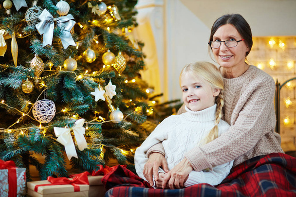 Dikkatli büyükanne torunu Noel gecesi kucaklayan - Fotoğraf, Görsel