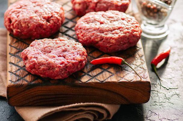 Close up of raw ground meat beef burgers on a wooden board.  - Foto, Imagen