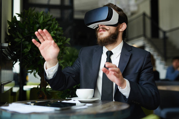 Neugieriger Geschäftsmann blickt in Brille auf virtuelle 3D-Realität - Foto, Bild