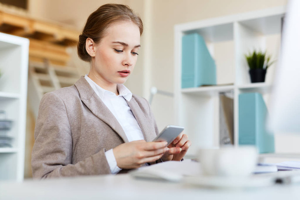 Mladá podnikatelka s smartphone SMS od její pracoviště na konec - Fotografie, Obrázek