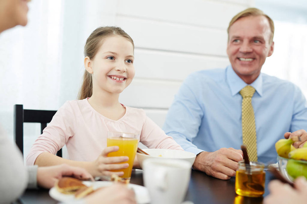 女の子と彼女の父親は、朝食のテーブルで座っている笑顔 - 写真・画像