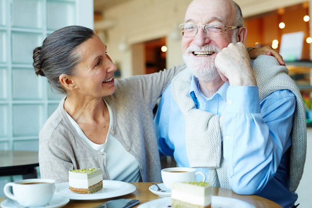 Любящая зрелая женщина обнимает своего счастливого мужа в кафе
 - Фото, изображение
