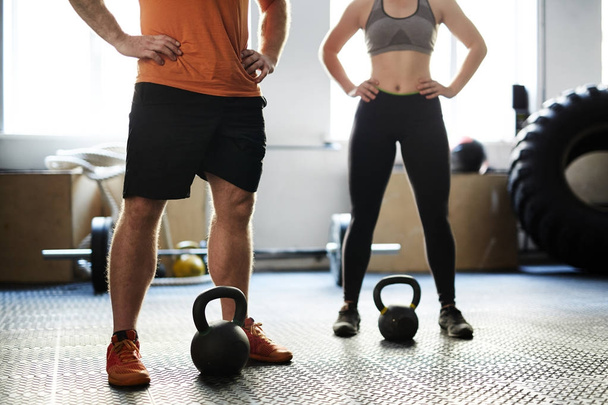 Hombre y mujer irreconocibles que tienen entrenamiento de fitness con pesas en el gimnasio
 - Foto, imagen
