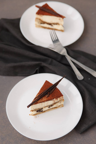 Zavřít pohled ze dvou narozeninových dortů na bílé talíře, vidličky a ubrousky - Fotografie, Obrázek