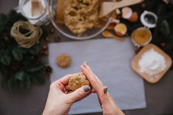 Female hands cooking walnut cookies with cooking stuff on background  - Fotografie, Obrázek