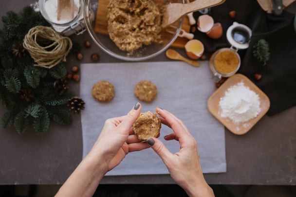 Weibliche Hände kochen Walnusskekse mit Kochutensilien im Hintergrund  - Foto, Bild