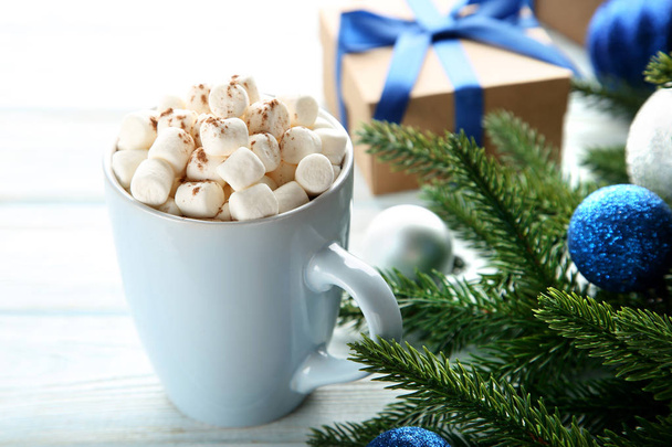 Cappuccino with marshmallow in mug and fir-tree branches on wooden table - Fotografie, Obrázek