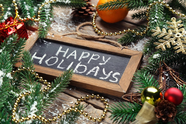 Inscription Happy Holiday on wooden frame with fir-tree branches and baubles - Photo, Image