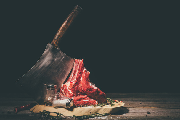 rohe Schweinerippchen mit Metzgerspalter und Gewürzen auf Holzbrett - Foto, Bild