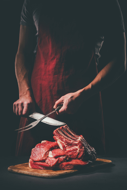 Metzger Schärfmesser zum Schneiden von rohem Fleisch auf Holzschneidebrett - Foto, Bild