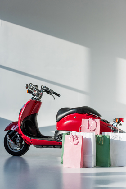scooter vintage rojo y bolsas de compras arregladas
 - Foto, imagen
