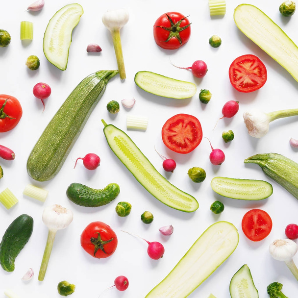 Rostlinné složení s nakrájené cukety, rajčata, cibule česnek, zahradní ředkvičky a Růžičková kapusta na bílém pozadí  - Fotografie, Obrázek