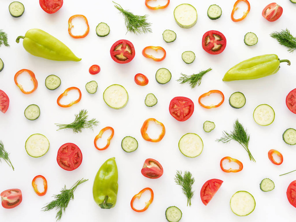 Food composition including peppers, tomatoes, cucumbers and greenery isolated on white background - Фото, зображення