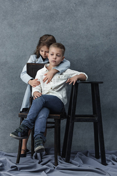 A portrait of little girl and a boy on the gray background - Fotografie, Obrázek