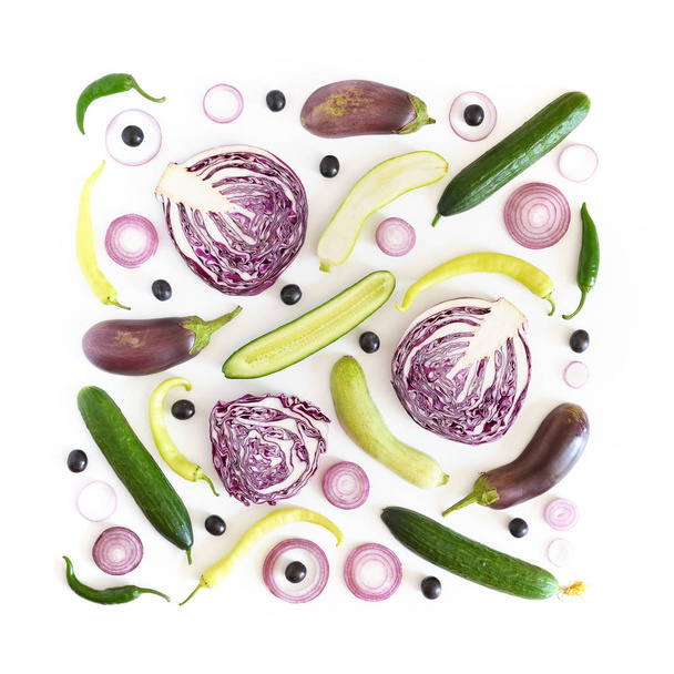 Composition of cutted and whole cucumbers, zucchinis, red cabbages, onions, olives and chili peppers on white background - Photo, image