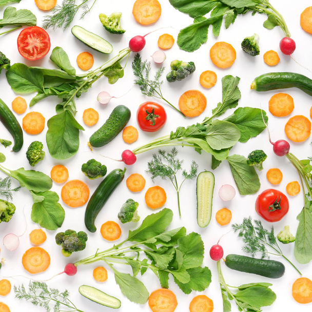 Composizione vegetale con tondi di carote, cetrioli affettati, peperoncini, pomodori, broccoli e foglie verdi
 - Foto, immagini
