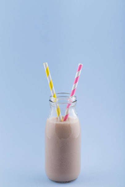 Chocolate Smoothie in Glass Bottle on a Blue Background - Foto, afbeelding