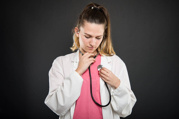 Attractive female doctor  holding stethoscope consulting herself - Photo, Image