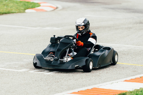 Женщина за рулем гоночного автомобиля на спортивной трассе
 - Фото, изображение