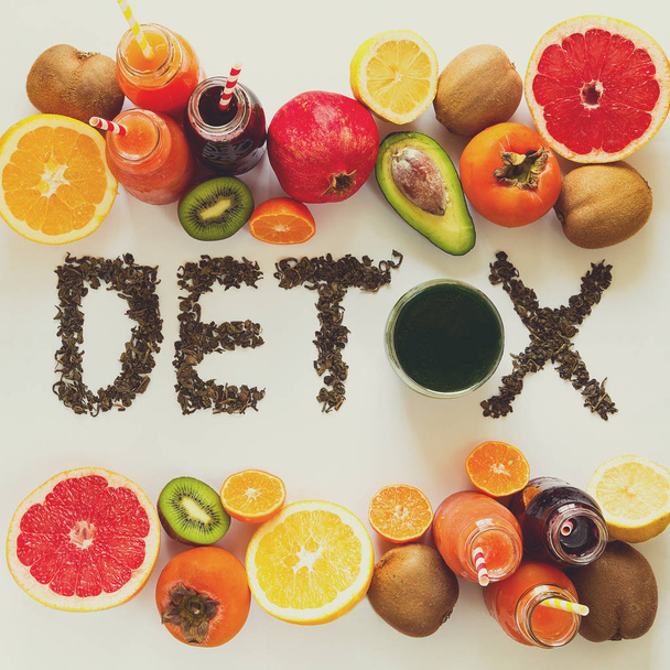 Healthy eating concept. Word 'detox' from green tea with colorful smoothies and fruits. Top view - Foto, Imagen