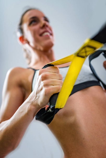 Genç kadın trx üzerinde spor salonunda egzersiz - Fotoğraf, Görsel