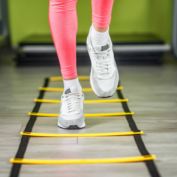 Mujer joven haciendo ejercicio sobre escaleras en el gimnasio
 - Foto, Imagen